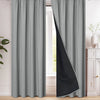 A pair of gray and black blackout curtains hanging in a window frame.