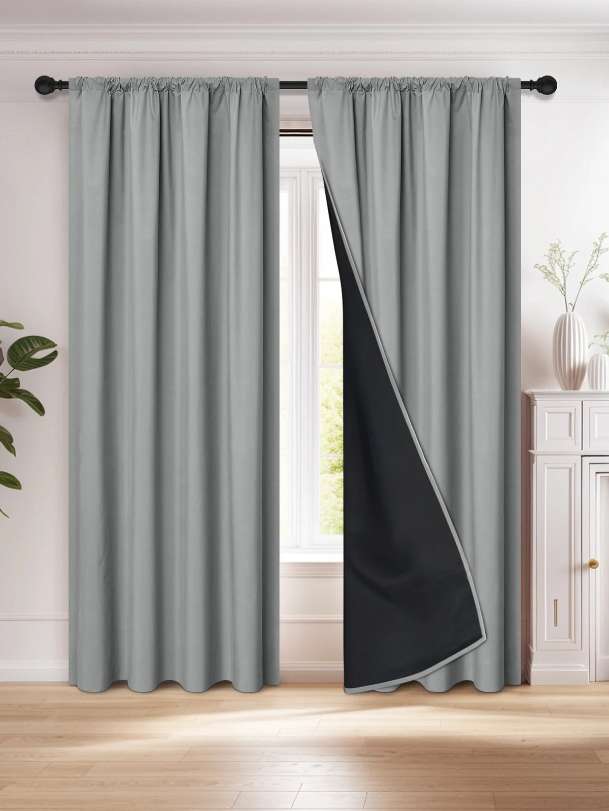 A pair of gray and black blackout curtains hanging in a window frame.