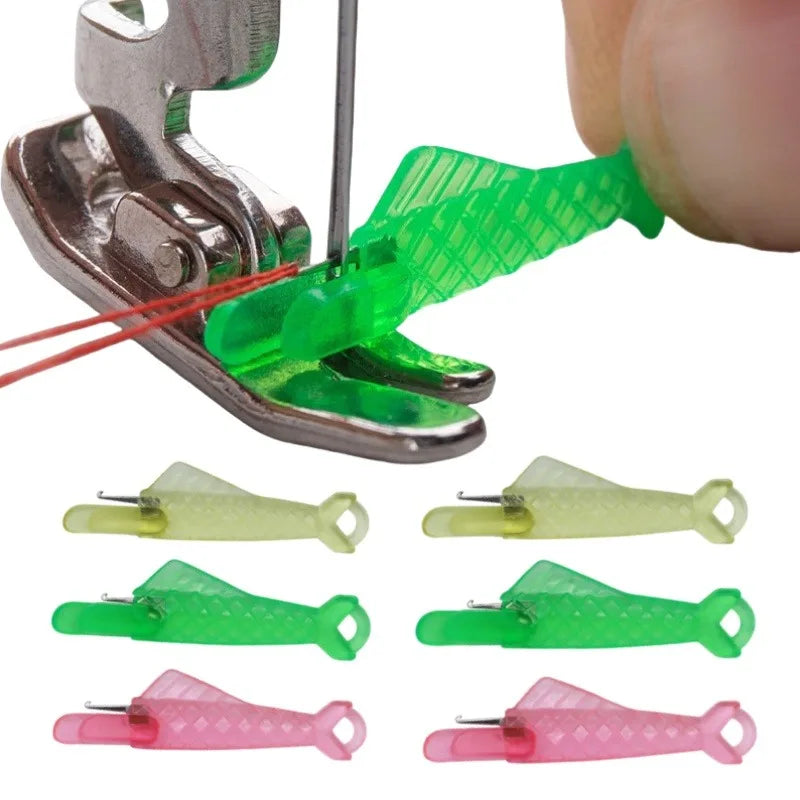 A hand sewing needle threader kit showing a green plastic tool being used to thread a needle.