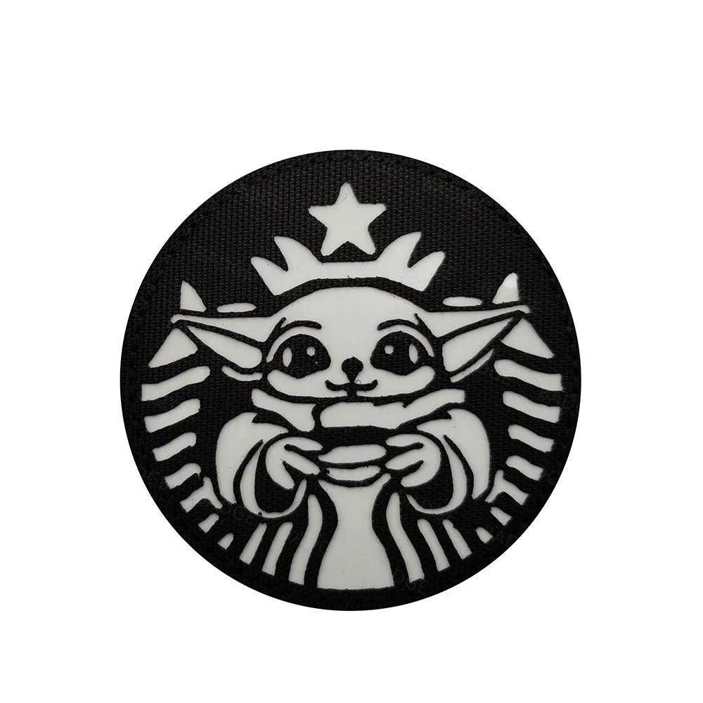 A black circular patch featuring a white Star Wars-style droid face wearing a crown.