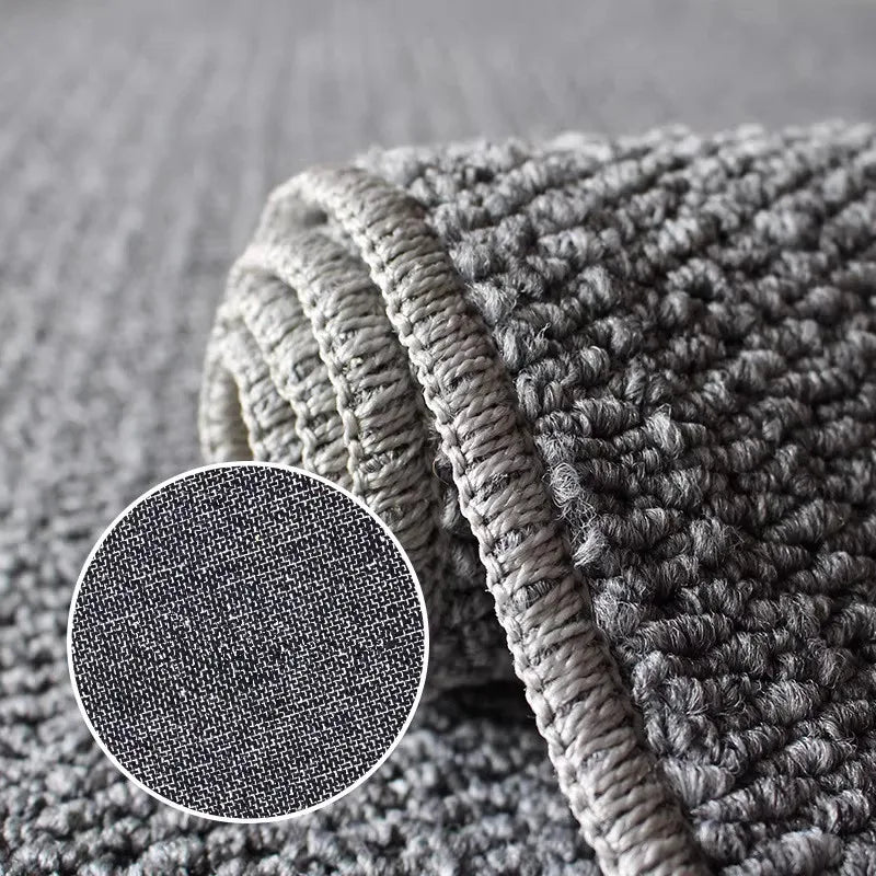 A close-up of a thick, textured gray sisal jute rug folded on a surface.