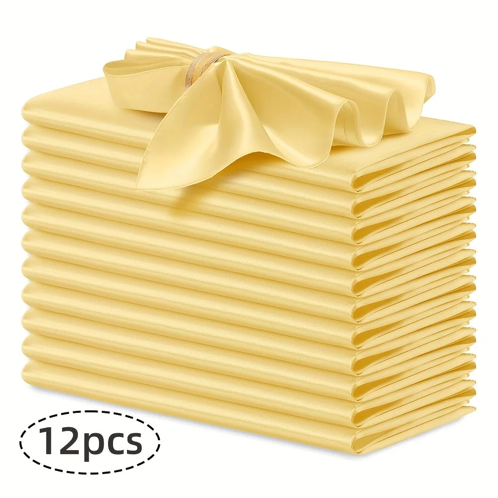 A stack of twelve silky satin yellow dinner napkins tied with a ribbon.