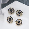 Four gold-toned floral rhinestone crystals with dark blue and clear accents displayed on a white surface.