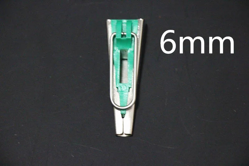 A close-up view of a silver and green precision bias tape maker with a 6mm measurement mark.