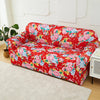 A vibrant red floral print slipcover on a sofa and chair, displayed on a light carpet.