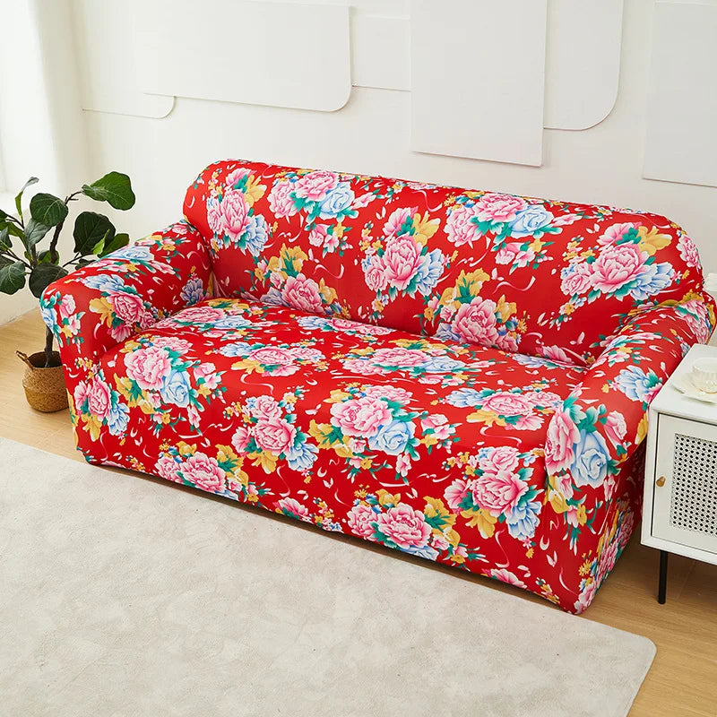 A vibrant red floral print slipcover on a sofa and chair, displayed on a light carpet.