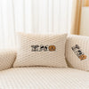 A cream-colored knitted cushion featuring a pattern of cartoon dogs.