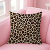 A square decorative pillow cover with a brown and black leopard print fabric resting on a pink sofa.