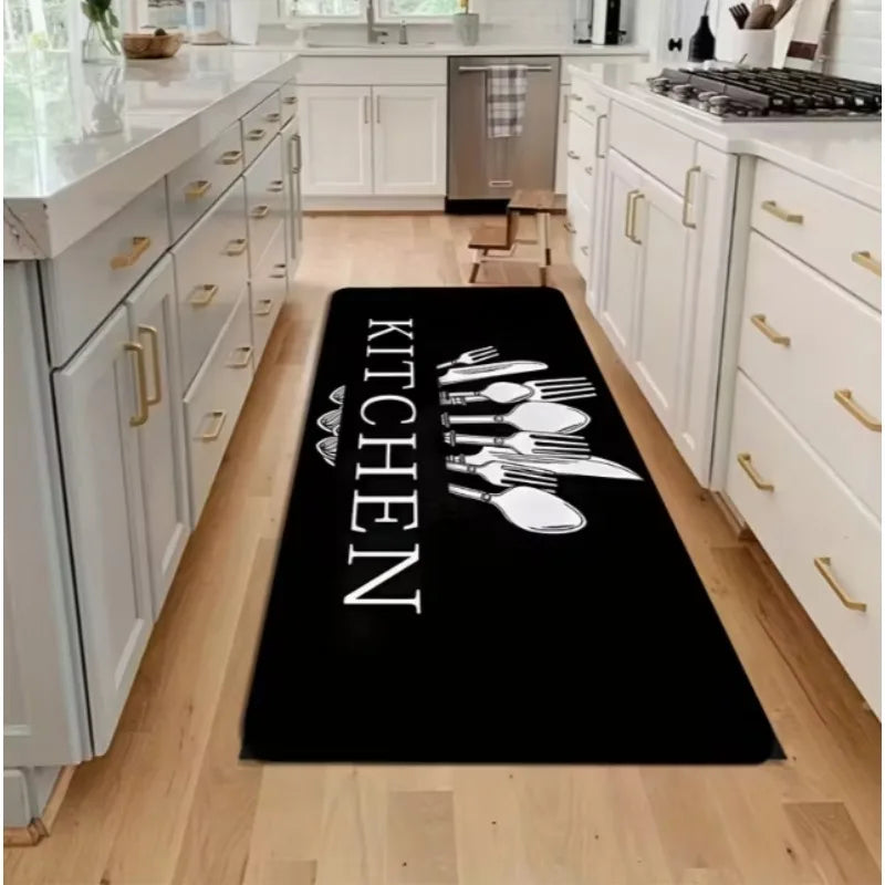 Black non-slip flannel area rug with the word KITCHEN written in white text placed on a light wood floor.