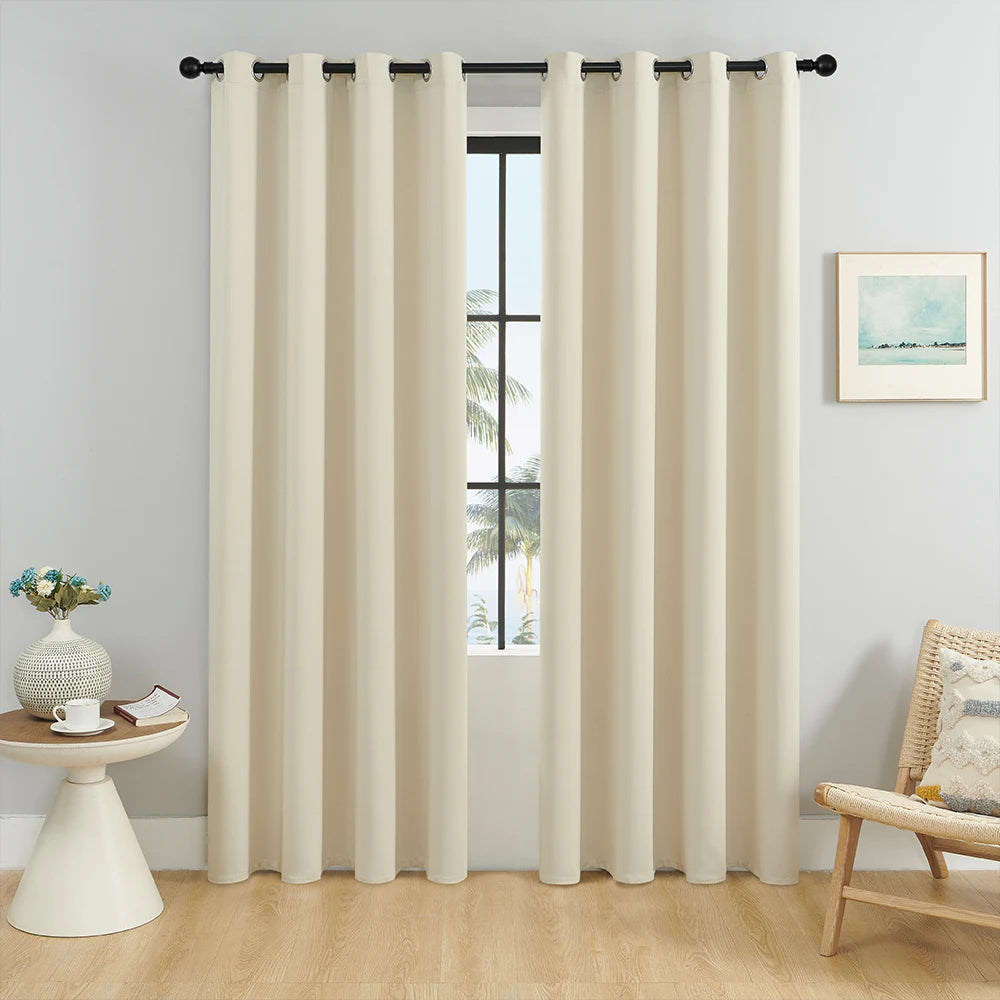 Solid blackout window curtain in beige fabric hanging in a window frame.