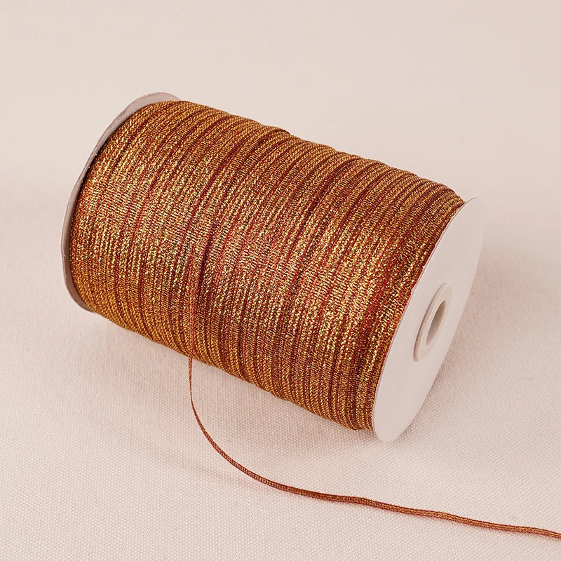 A roll of 10-meter gold and silver glitter satin ribbon with a white core.