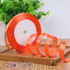 Roll of orange satin ribbon used for crafting or decoration