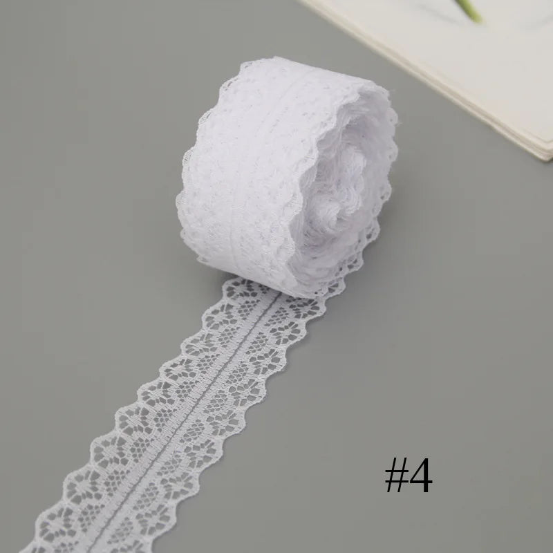 A roll of white floral lace ribbon with a cotton trim for sewing and crafts.
