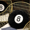 A black soft memory foam ball pillow cushion resting in a gold wire basket.