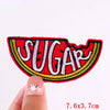 Red embroidered letter patch spelling SUGAR on a finger