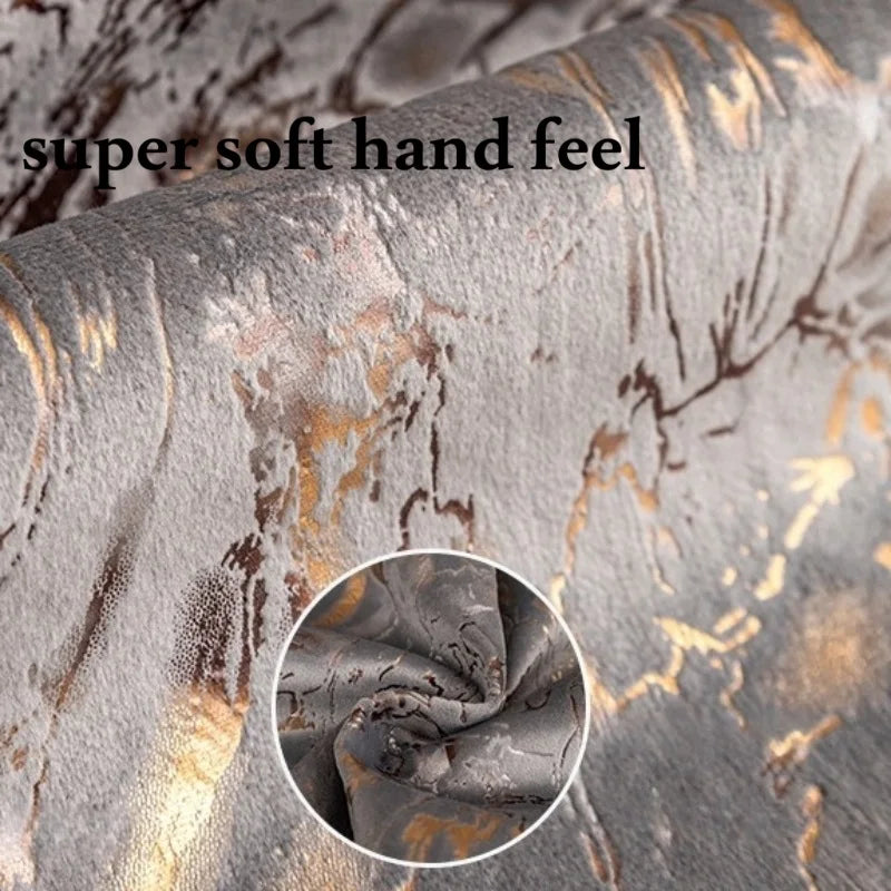 Close-up of a gray velvet fabric with gold foil detailing showing a soft hand feel texture.
