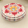 A round bohemian tatami cushion featuring a vibrant floral pattern in red, orange, yellow, and purple on a cream background.