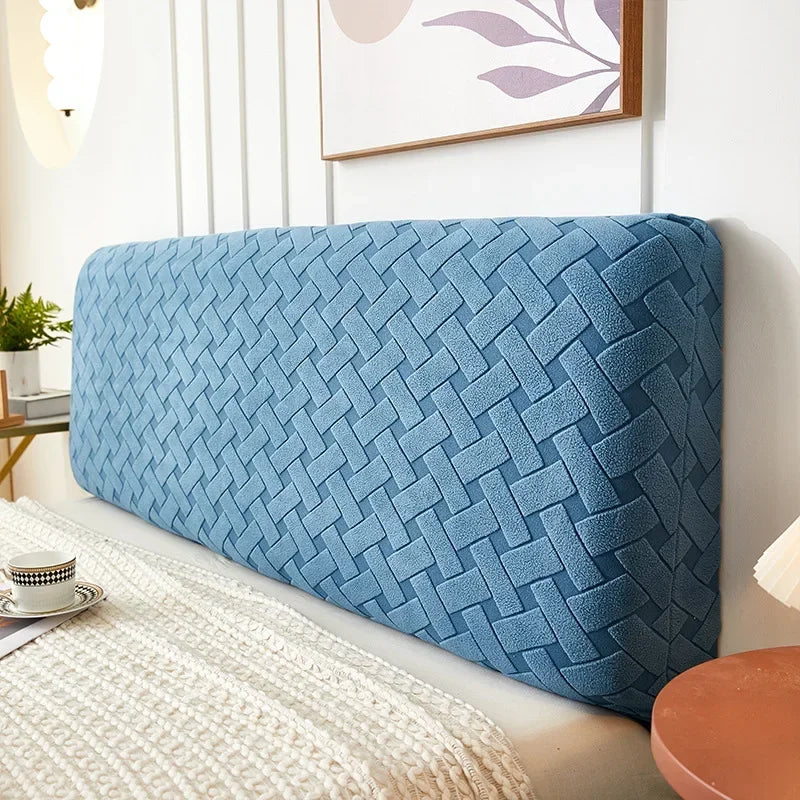 A light blue plush quilted headboard cover resting on a white surface.