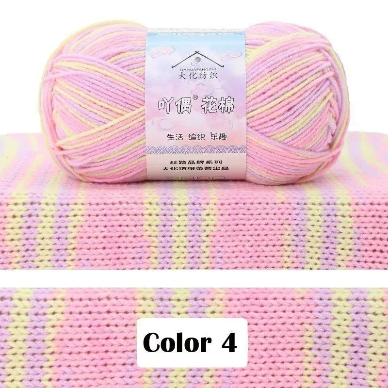 A ball of pink yarn labeled Color 4 for gradient projects, displayed on a pink and yellow striped knitted fabric.