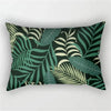 A dark green tropical leaf print pillowcase featuring various shades of green and olive on a black background.