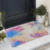 A thickened silk wool area rug featuring a multicolored abstract pattern of pink, blue, and cream colors placed on a light su