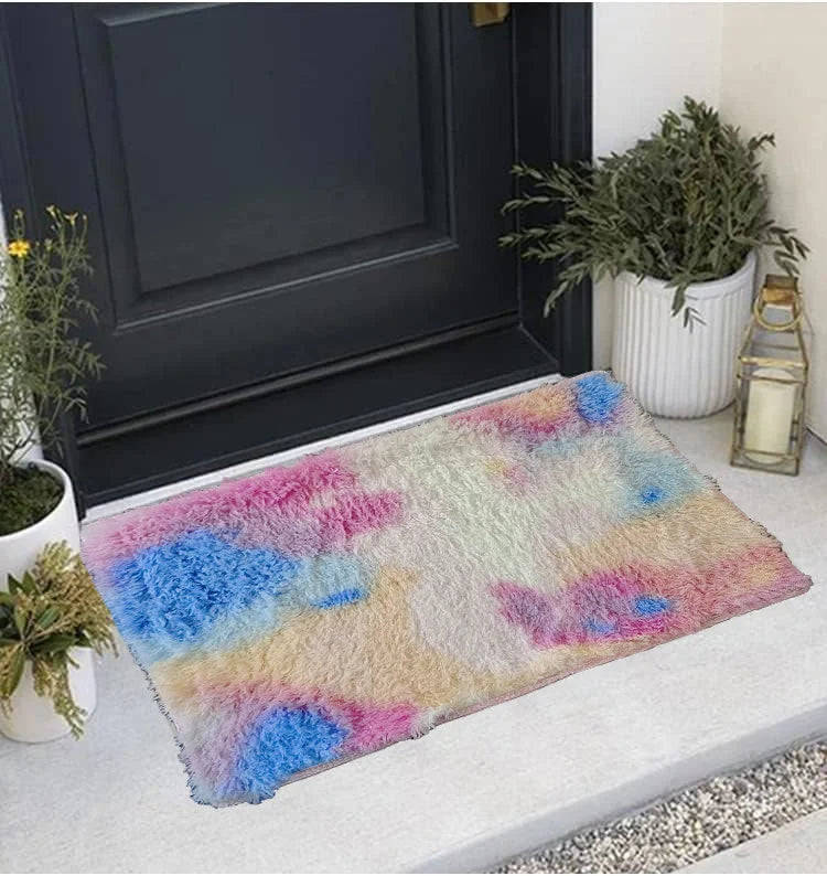 A thickened silk wool area rug featuring a multicolored abstract pattern of pink, blue, and cream colors placed on a light su