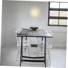 A rustic wooden dining table with white chairs and a pendant light fixture in a bright room.