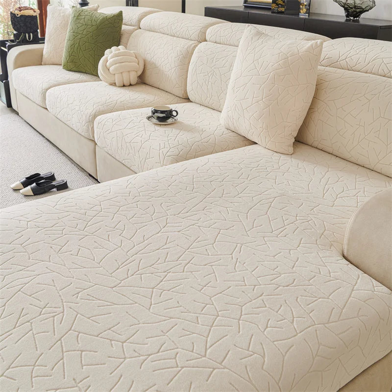 A cream-colored sofa cover featuring a subtle, textured branch pattern on the upholstery.