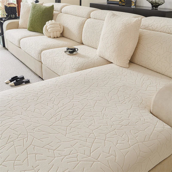 A cream-colored sofa cover featuring a subtle, textured branch pattern on the upholstery.