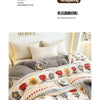 A cozy white and gray lamb'swool winter blanket with floral embroidery is displayed on a bed.