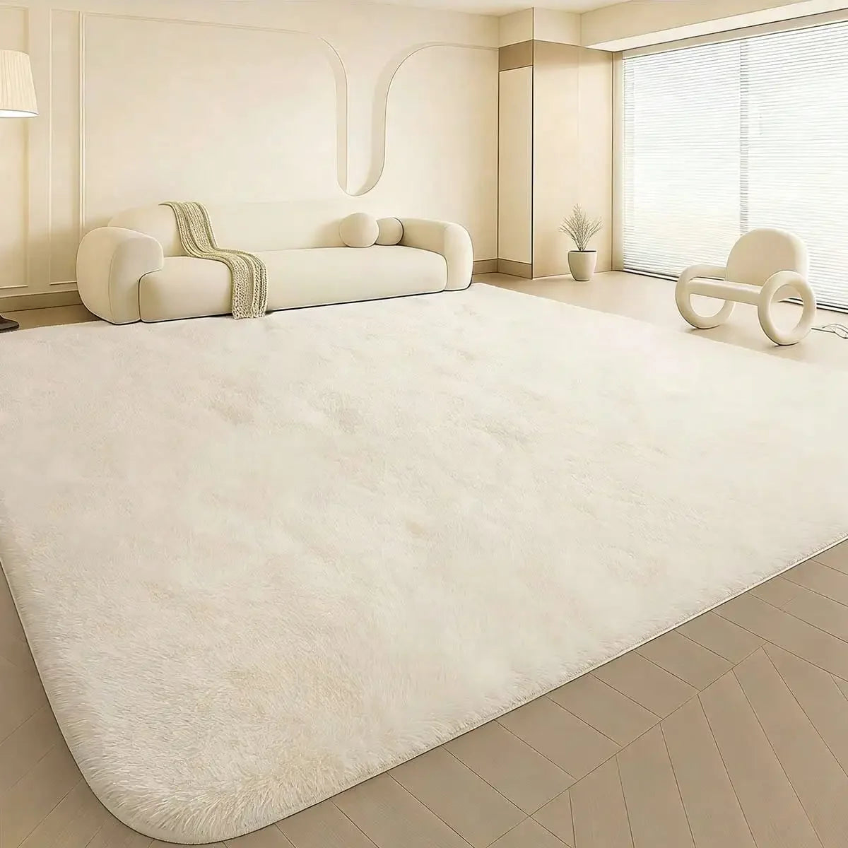 A plush, long-pile white area rug is displayed on a light wood floor in a modern, bright room.
