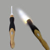 A wooden and black rechargeable LED crochet hook set is shown with a bright light beam.