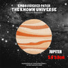 Embroidered patch of Jupiter with striped orange and white bands against a dark starry background