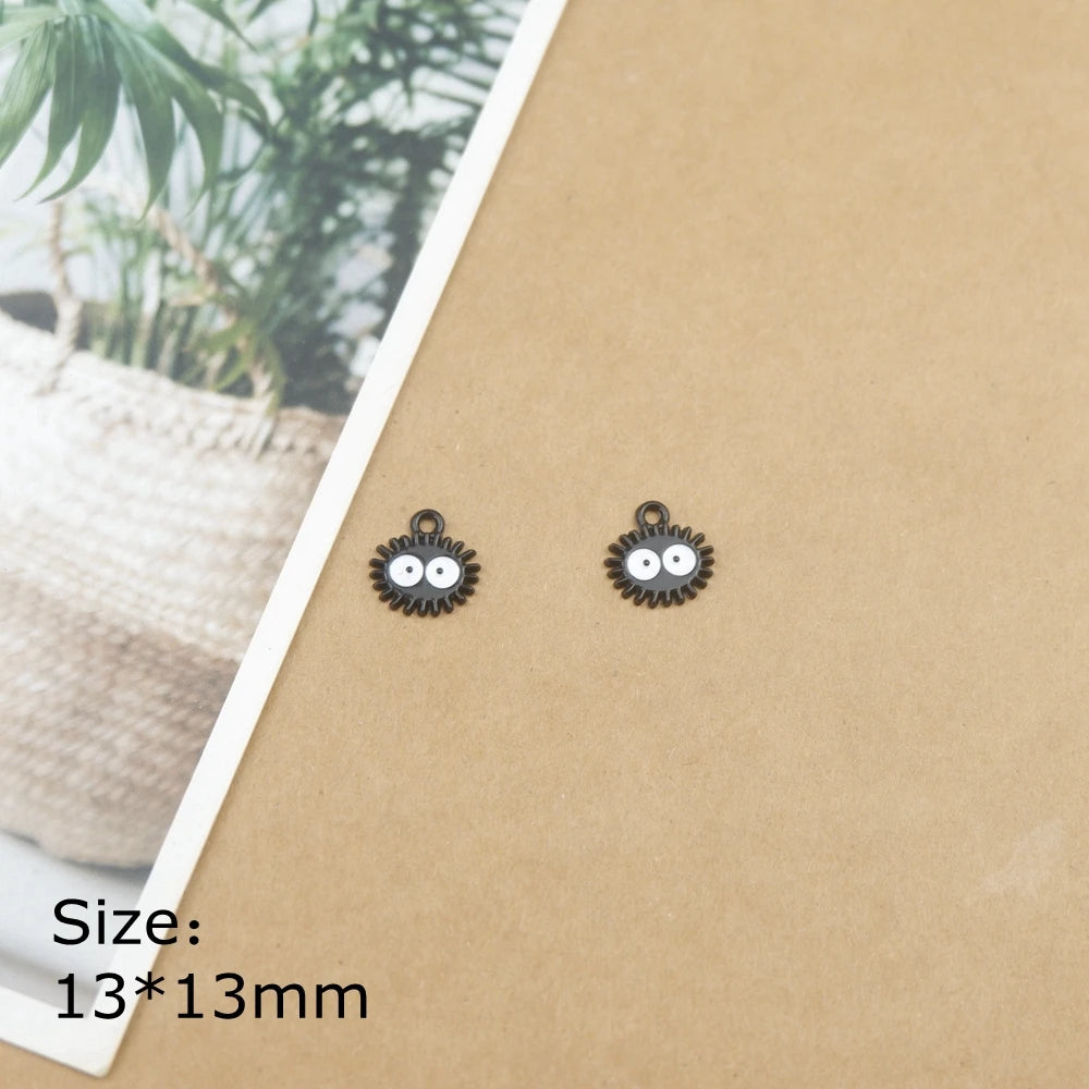 A pair of small, round, black ladybug resin charms on a brown card.