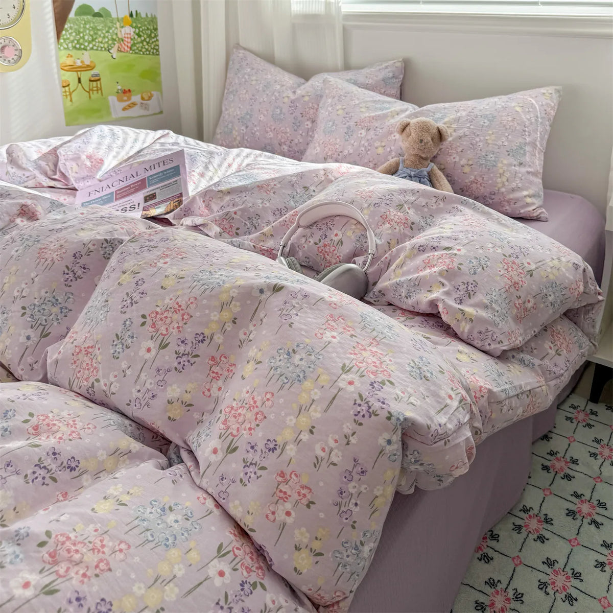 A pink floral microfiber duvet set with matching pillows and a teddy bear toy displayed on a bed.