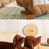 A brown corduroy dachshund body pillow resting on a light-colored surface.