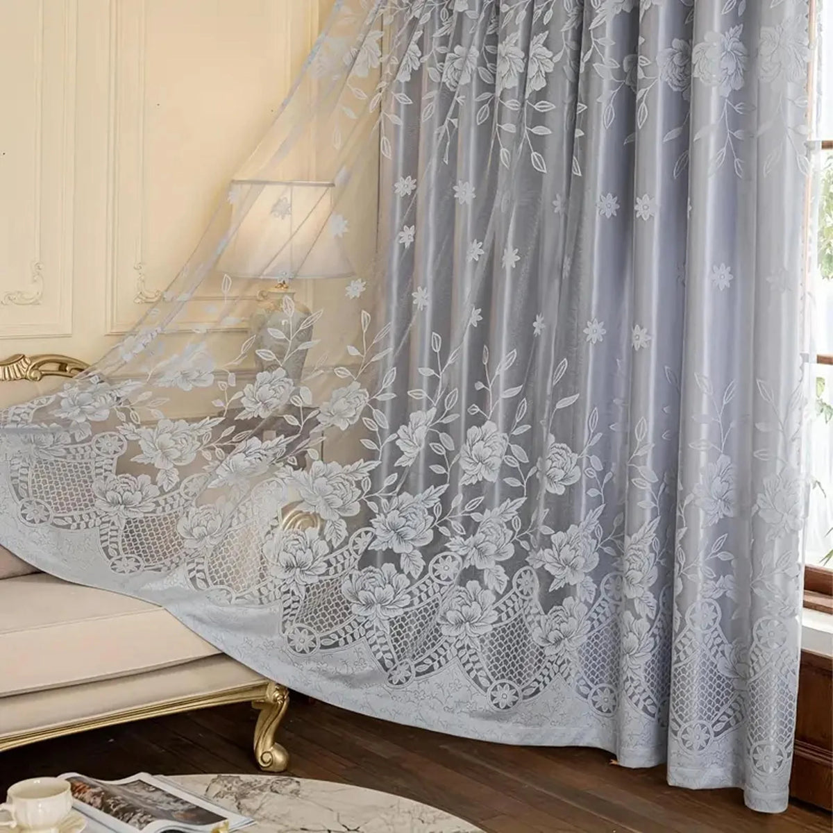Gray vintage floral blackout curtain draped over a window with white lace detailing
