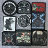 A collection of dark, tactical skull and military themed patches and badges on a gray background.