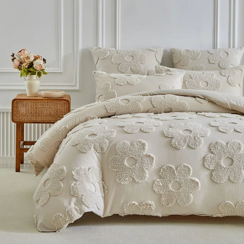 A beige tufted floral duvet cover set with matching pillowcases displayed on a bed against a white paneled wall.