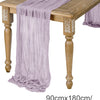 A purple semi-sheer gauze table runner draped over a wooden table.