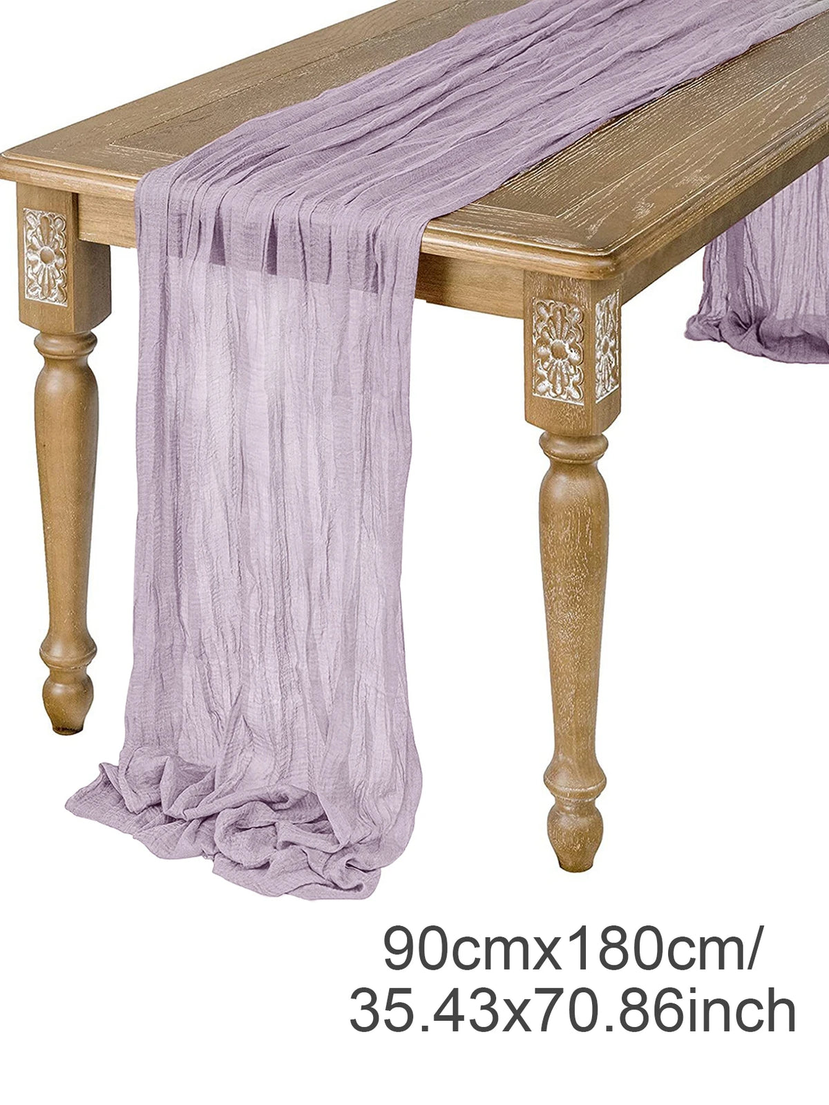 A purple semi-sheer gauze table runner draped over a wooden table.