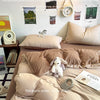 A bed with beige bedding and pillows, featuring inspirational quotes on the wall.