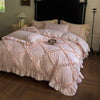 A pink ruffled duvet cover set with quilted detailing is displayed on a bed.