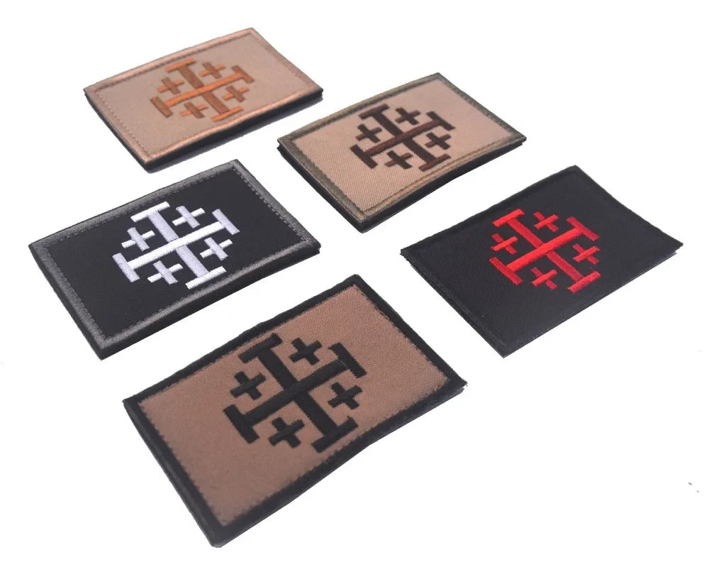 Four embroidered patches featuring a stylized Crusader and Knight symbol in brown, black, and red thread.