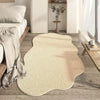 A cream colored irregular plush area rug placed on a light wood floor in a modern living space.