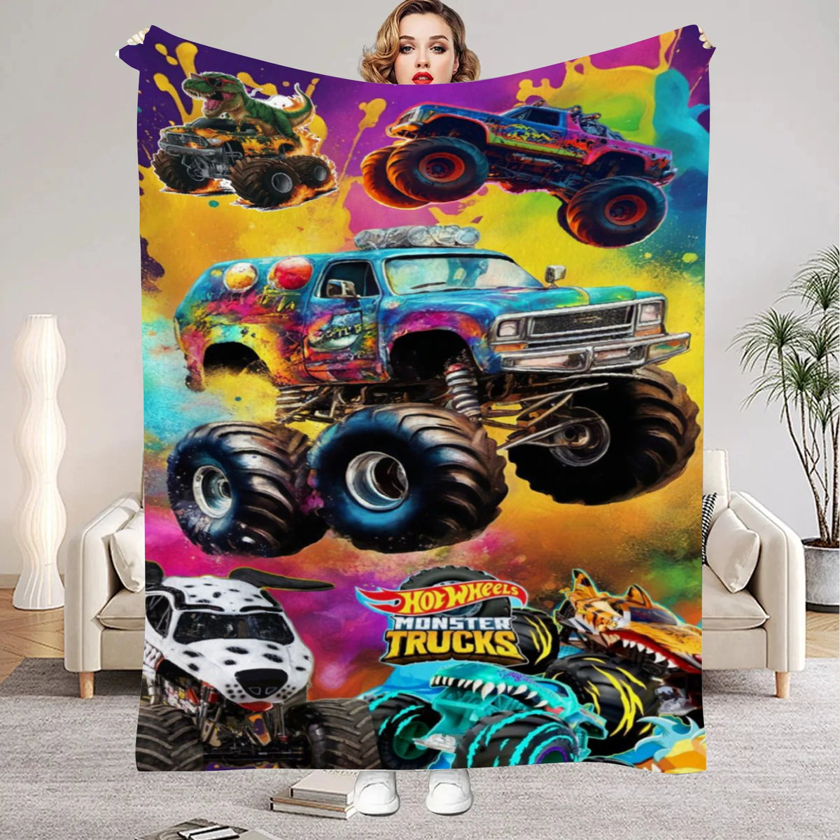 A colorful Monster Trucks flannel throw blanket featuring various monster truck designs and vibrant paint splashes.