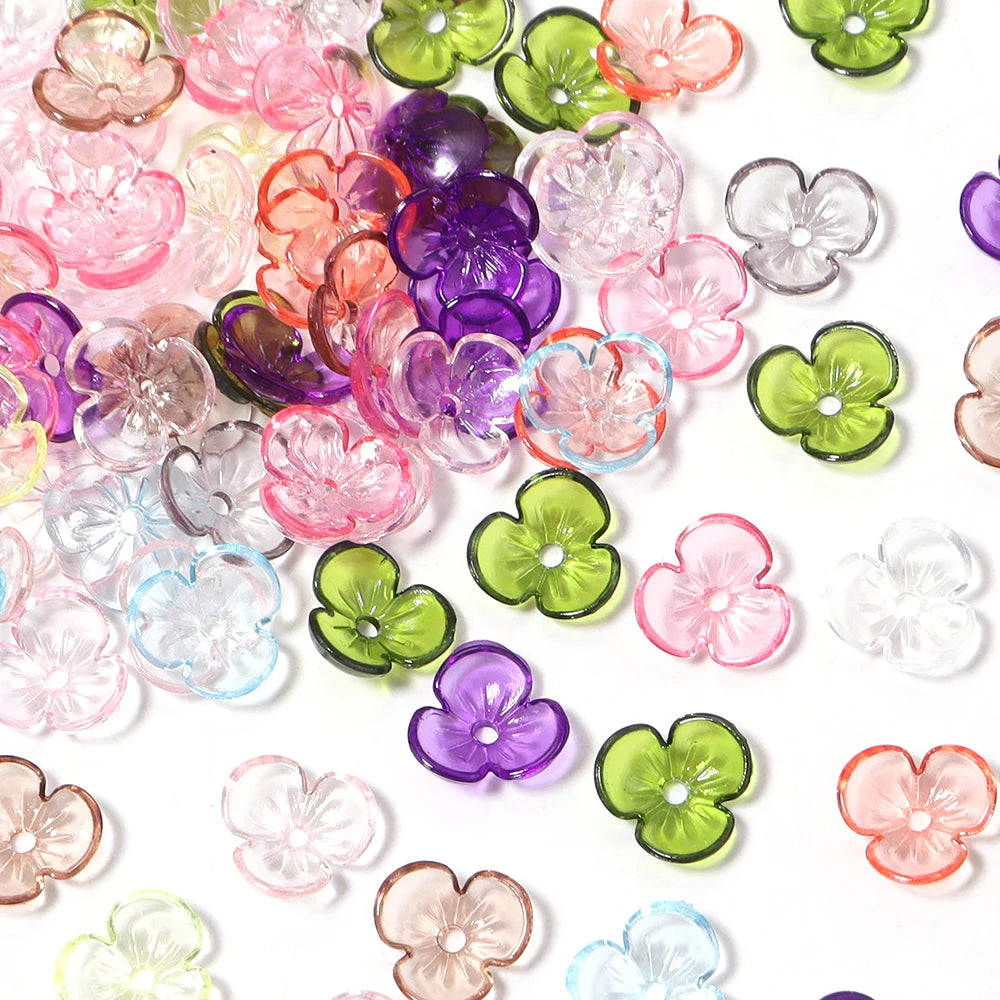 A collection of colorful resin flower bead caps in various shades including pink, purple, green, and clear.