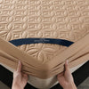 A beige quilted mattress protector is shown being held by hands, featuring the Healthy Sleep brand.