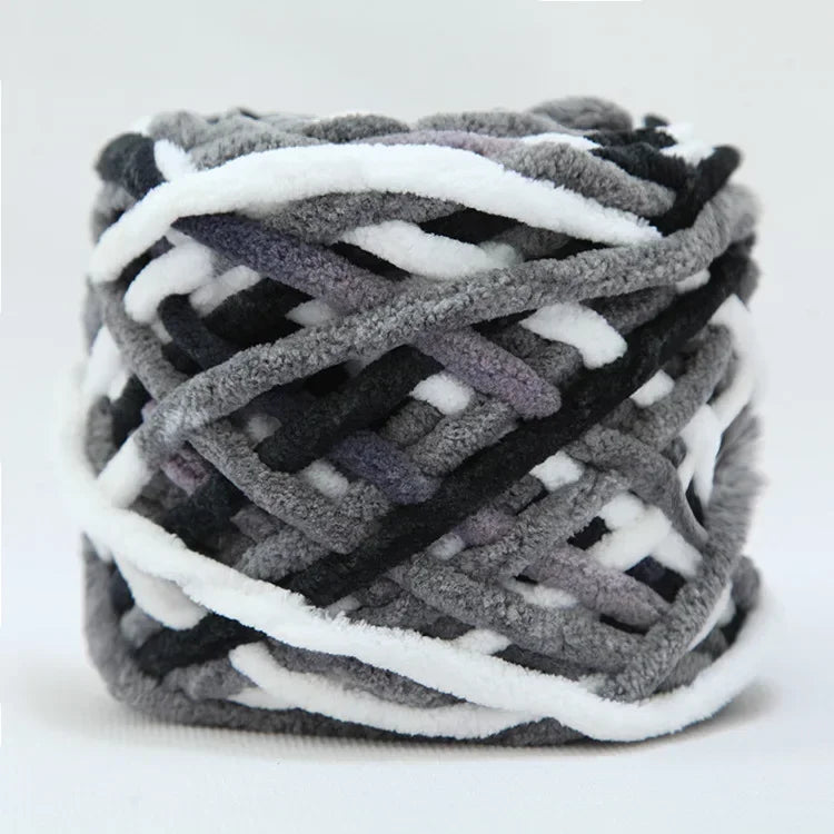 A ball of soft chenille knitting yarn featuring a mix of gray, black, and white strands.