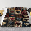 A quilted flannel throw blanket featuring a patchwork design with various heart patterns in deep reds, blues, and browns.